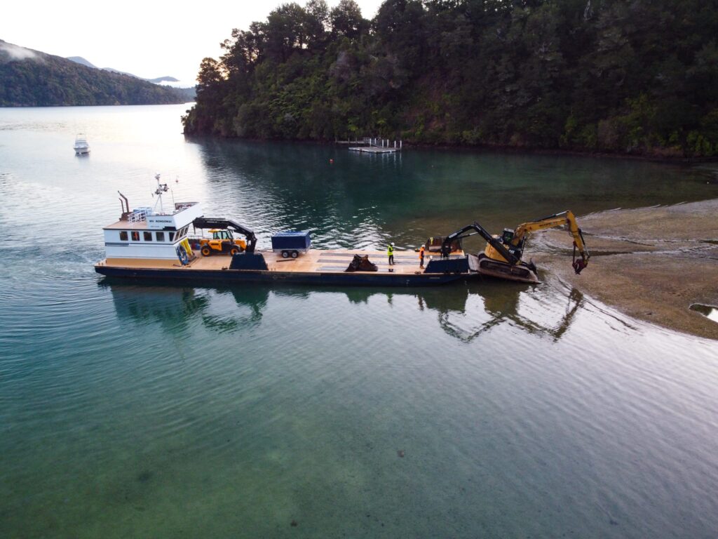 image of Scope Group excavation machinery being delivered by boat at demolition and deconstruction project at Becks Bay, Marlborough, NZ