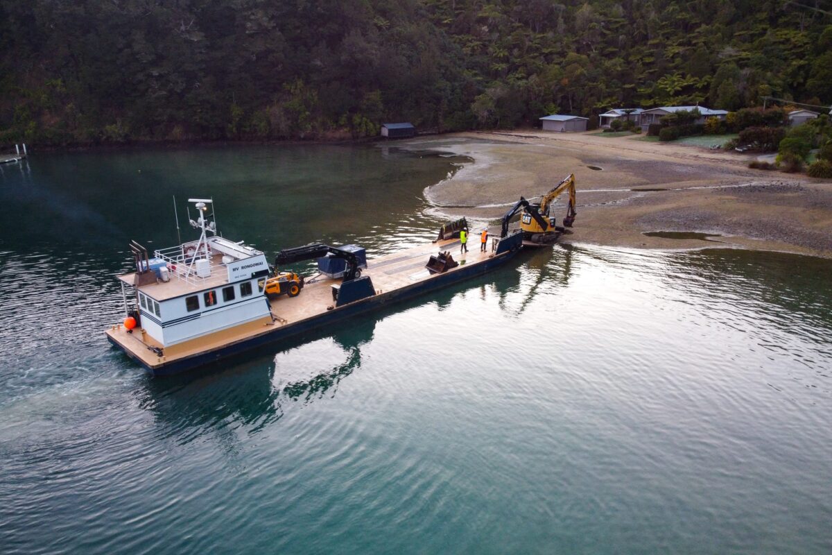 image of Scope Group machinery being delivered by boat at demolition and deconstruction project at Becks Bay, Marlborough, NZ