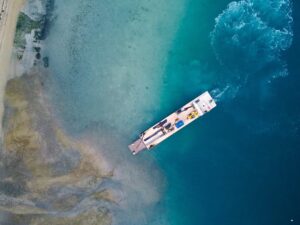 aerial drone image of Scope Group excavation machinery being delivered by boat at demolition and deconstruction project at Becks Bay, Marlborough, NZ