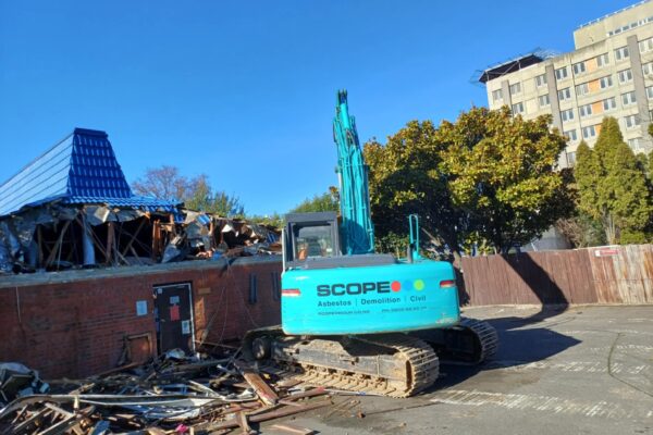 image of Scope Group excavator deconstructing Pizza Hut building by Scope Group in Dunedin, NZ