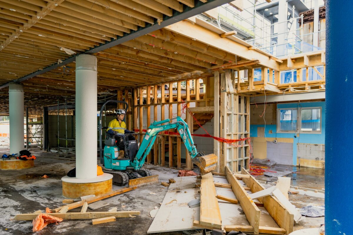 image of man operating small excavator inside Picton terminal being demolished and stripped out by Scope Group, NZ