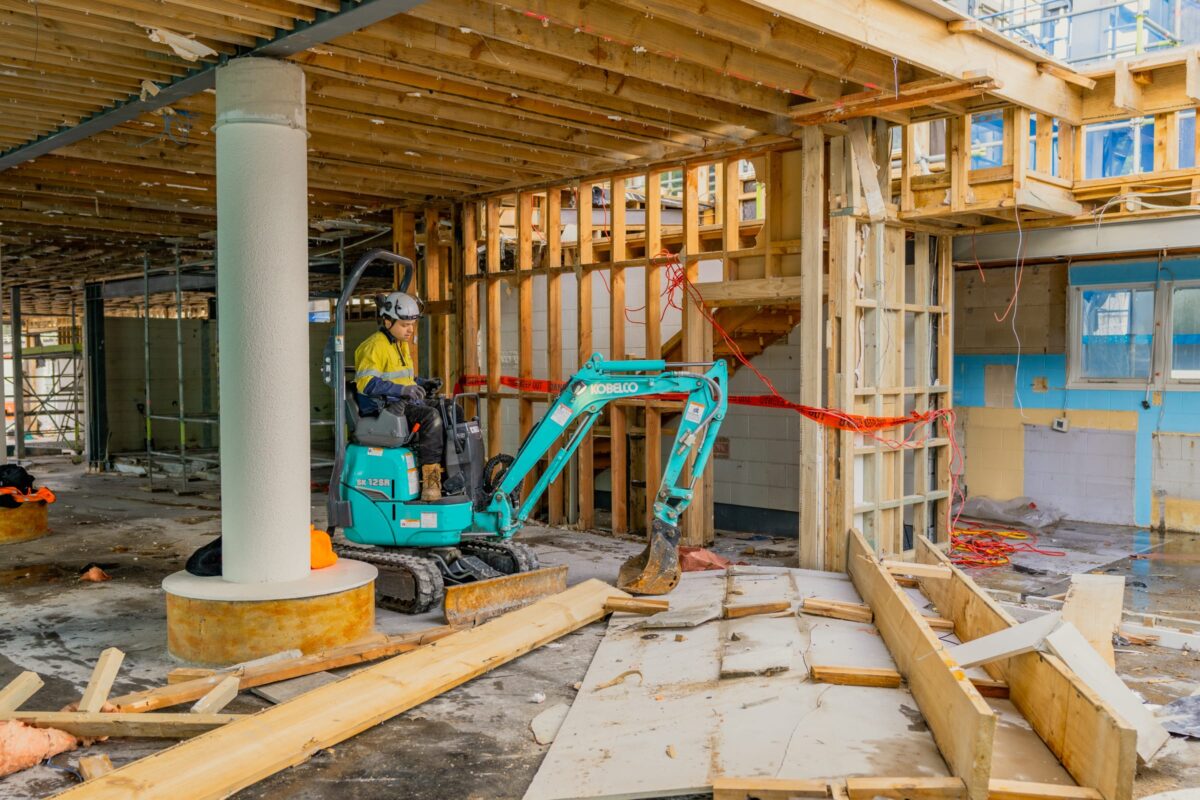 image of man operating small excavator inside Picton terminal being demolished and stripped out by Scope Group, NZ