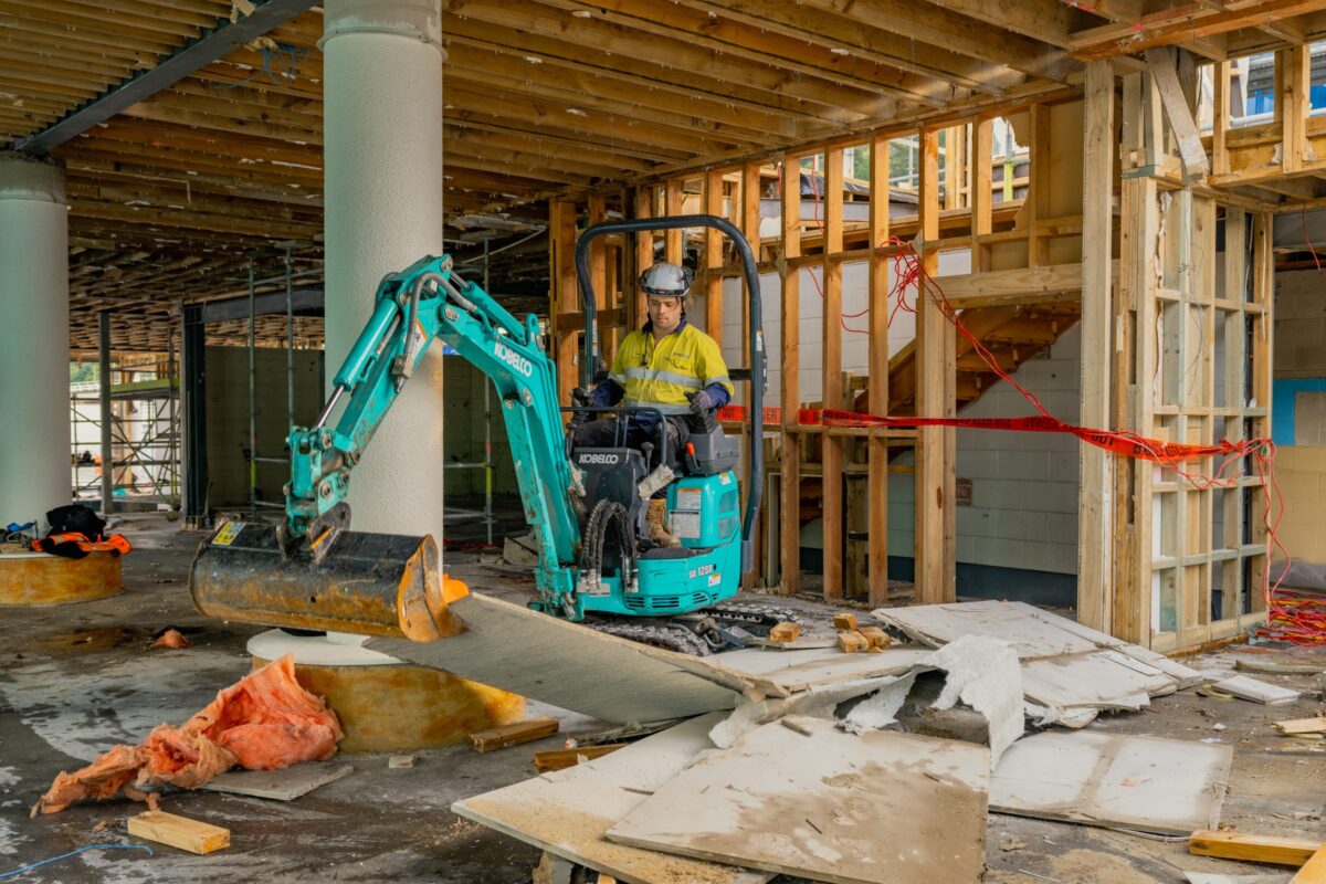 image of man operating small excavator inside Picton terminal being demolished and stripped out by Scope Group, NZ