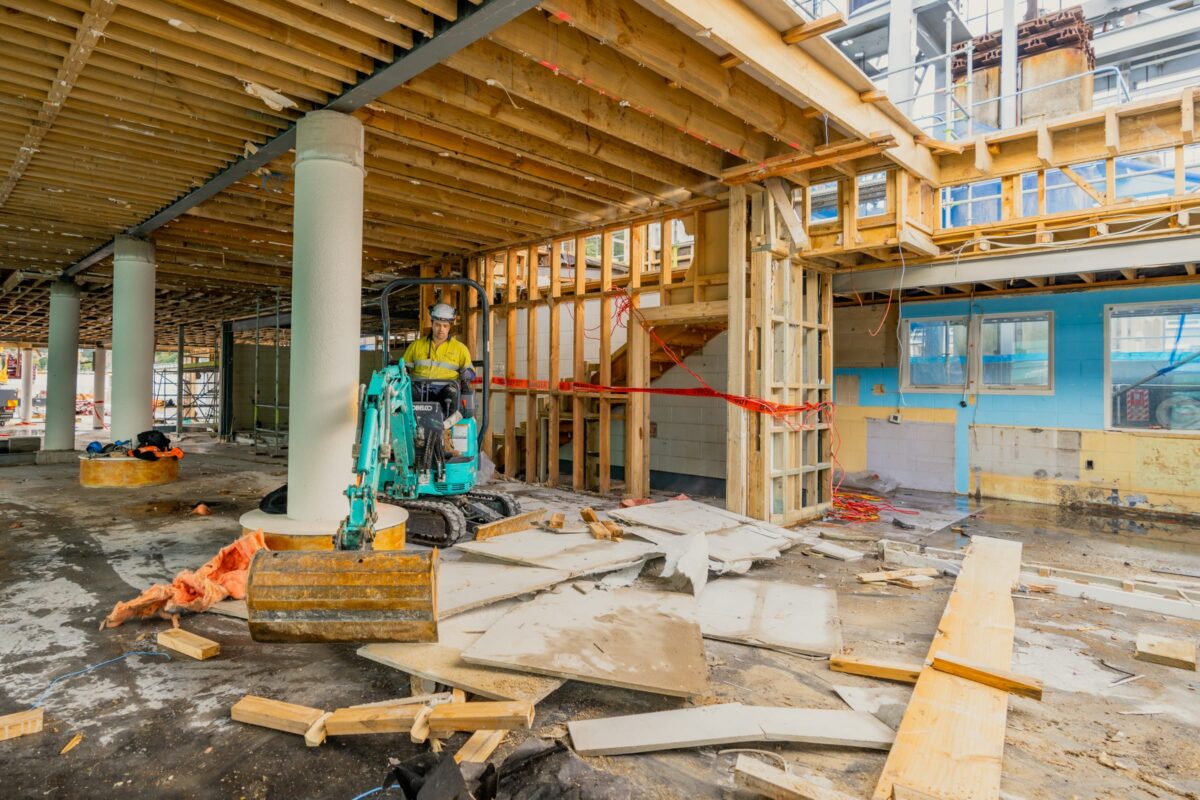 image of man operating small excavator inside Picton terminal being demolished and stripped out by Scope Group, NZ